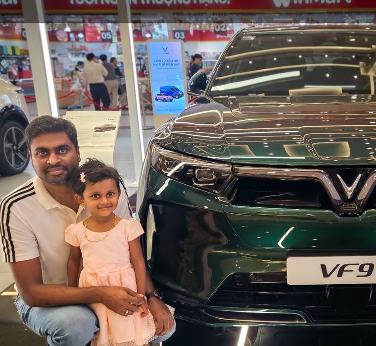 Manjunath and his daughter next to the VinFast VF9